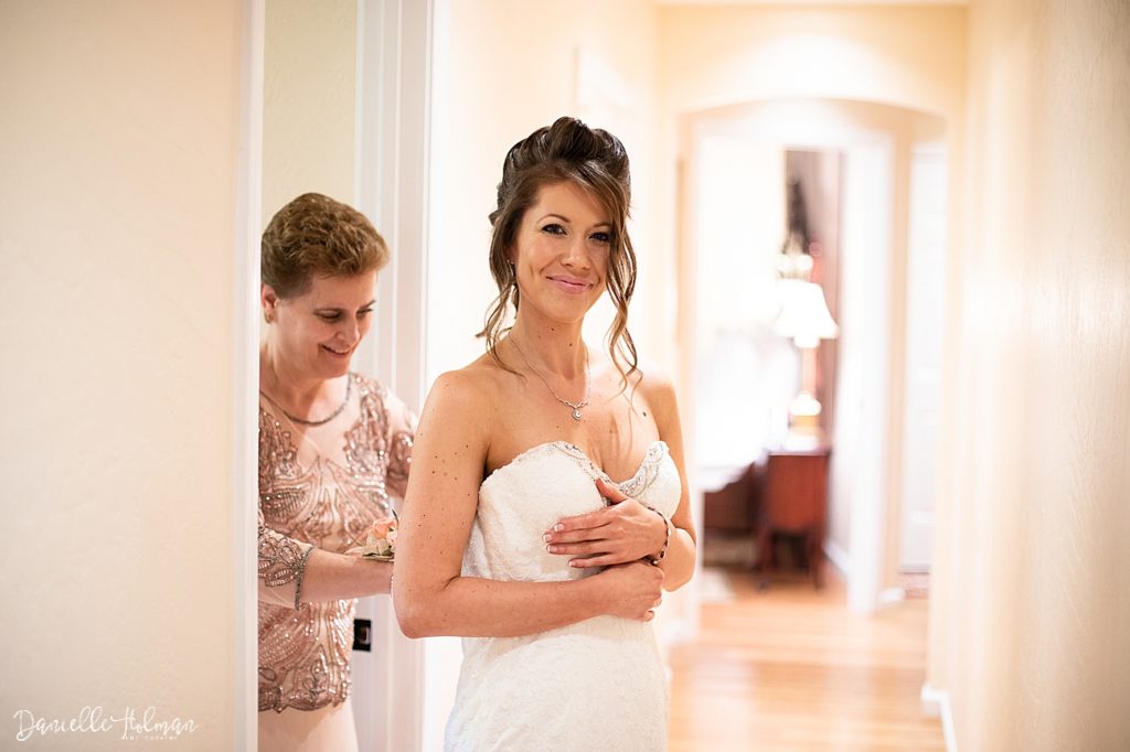 Mom helping bride with her wedding dress