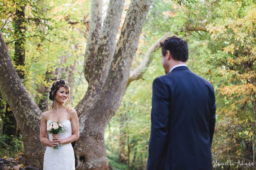 Bride looking at groom with fall foliage background